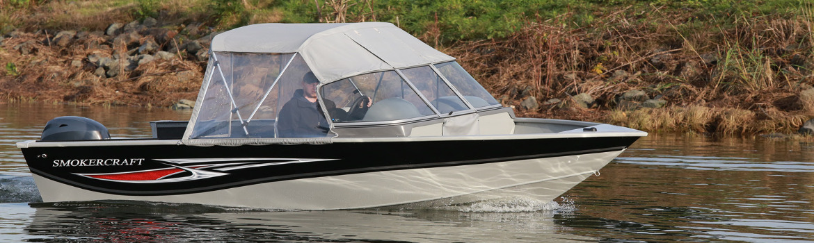 Man riding in a 2017 Smokercraft Osprey 162 boat on a body of water.